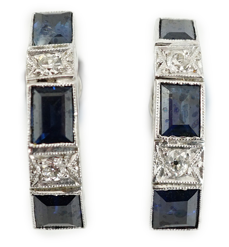 A pair of 9ct white gold, three stone sapphire and two stone diamond set half hoop ear clips, 16mm, gross weight 4.1 grams.
